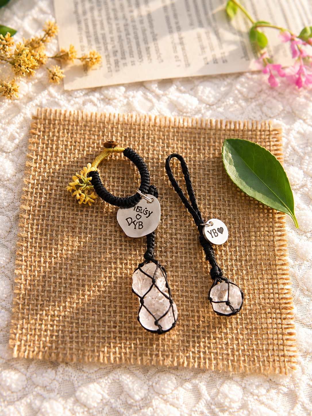 Black cord Clear Quartz pet pendant and double Clear Quartz owner bag charm with personalized round tags, displayed side by side on burlap