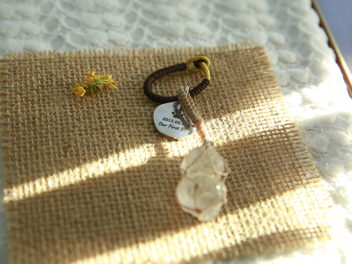 Back of the personalized double Clear Quartz bag charm tag with a paw print, meaningful date and message