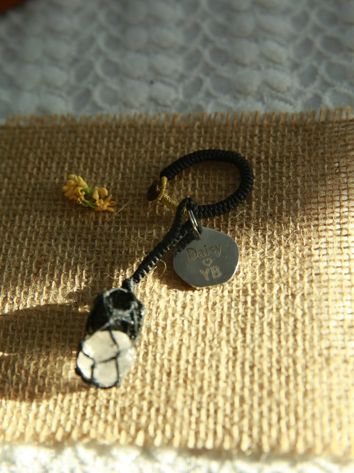 Black Obsidian above Clear Quartz in one handwoven black waxed cord net, with a personalized 20mm tag for a bag or keys